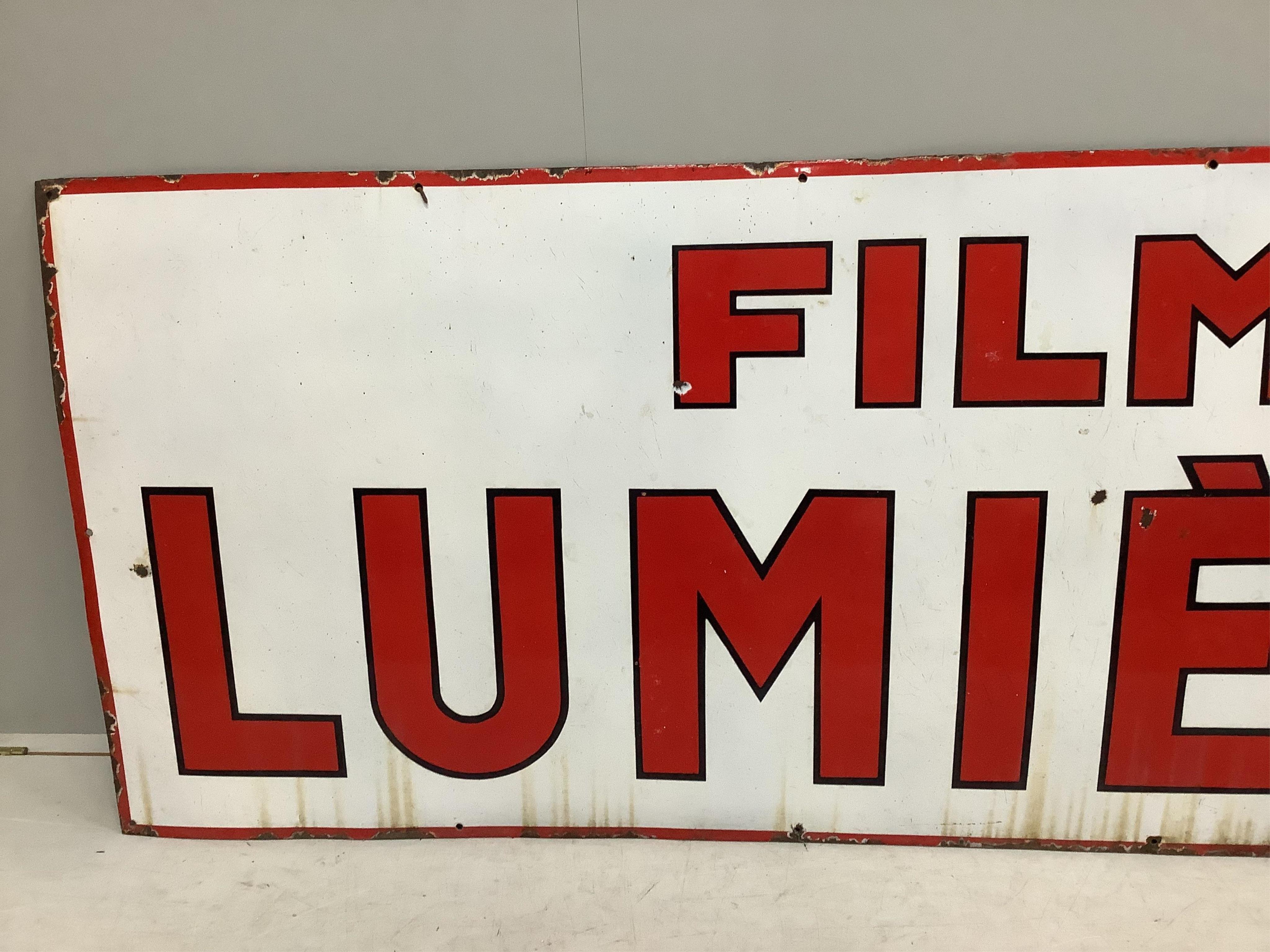 A large vintage French enamel advertising sign 'Film Lumière', width 246cm, height 95cm. Condition - fair